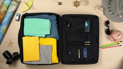 Woman packing suitcase, fast forward effect. Tourism, travel. Top view. Tourist's luggage and things on table