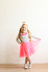 Portrait of cute little five year old girl with long blond hair wearing easter bunny ears on head,...