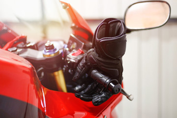 Obraz premium Black leather motorcycle gloves is lying on a red sports bike.