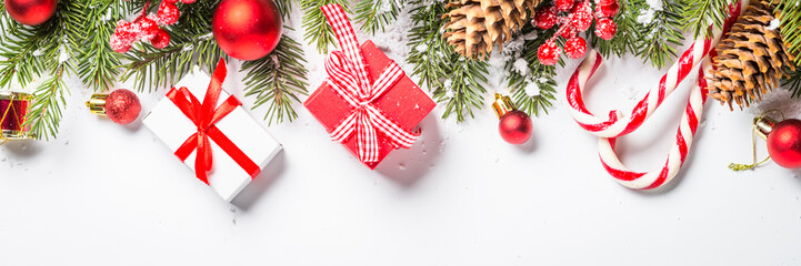 Christmas background with fir tree and decorations on white.