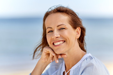 people and leisure concept - portrait of happy smiling woman on summer beach