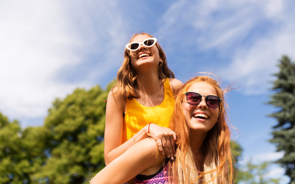 leisure, people and friendship concept - happy teenage girls or friends having fun at summer park