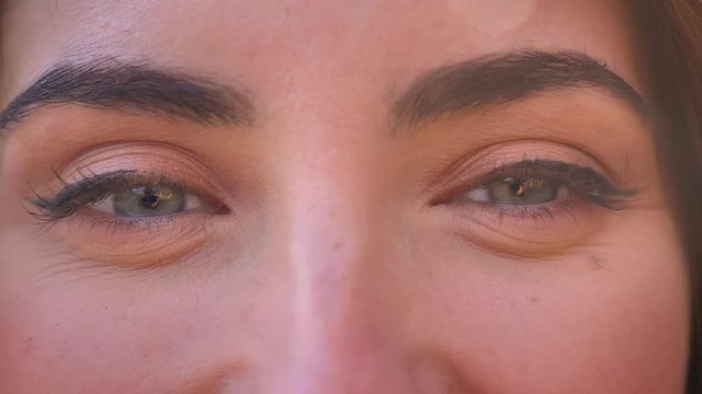 Close-up pretty face and blue eyes of caucasian woman looking straight at camera, open and natural