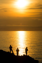 夕暮れの海と釣り人