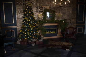 Christmas tree with yellow balls, candles and decorated fireplace