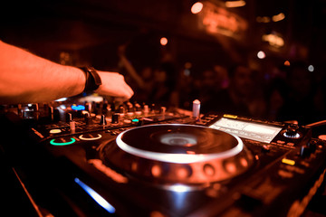 Dj mixes the track in the nightclub at party