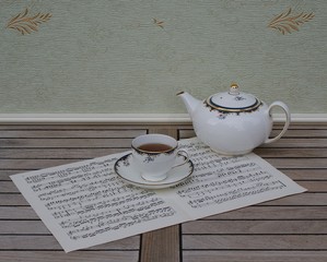 English teacup with saucer and teapot on a sheet of music