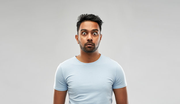 emotion, expression and people concept - shocked or scared man in t-shirt over grey background