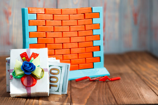 wall toys and red brick. near the gift box with cash dollars. have toning. The concept of buying real estate and you gift. discount or cash bonus