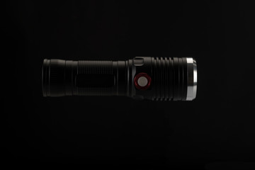 Tactical flashlight on a black background