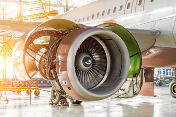 Opened hood aircraft engine jet under maintenance in the hangar.