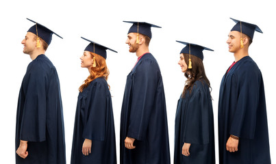 education, graduation and people concept - group of happy graduate students in mortar boards and...