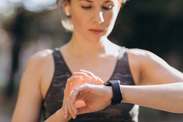 Fitness Woman In Wireless Earphones Using Smartwatch