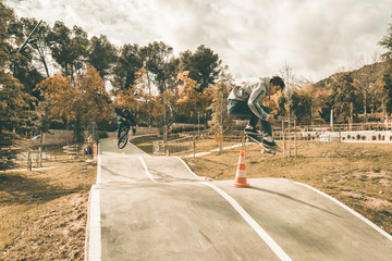 Guy skateboarding in a park. Skateboarder jumping on skateboard