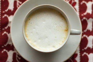 a Cup of coffee with a thick foam on a Christmas napkin