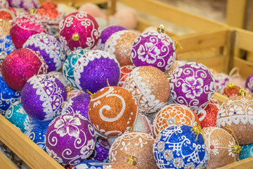 A full box of colorful brightly colored balls for the Christmas tree. group of objects. background of christmas balls