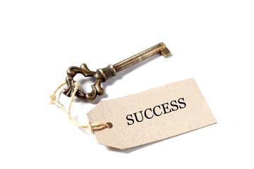 old antique key, a label  with the word success isolated on white background with copy space