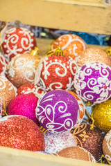 A full box of colorful brightly colored balls for the Christmas tree. group of objects. background of christmas balls