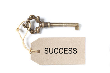 old antique key, a label  with the word success isolated on white background with copy space