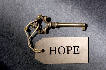 old antique key and a label with the word hope and copy space for your text rest on a slate  background