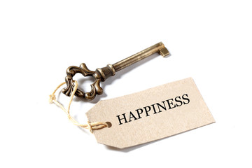 old antique key, a label and the word happiness isolated on  on white background with copy space