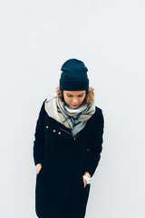 Female wearing coat, beanie hat and scarf