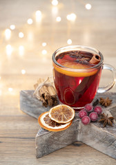 Home made mulled wine and Christmas lights on rustic star