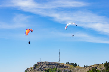 Paragliders soaring above the mountain top. Russia, Republic of Crimea. 06.13.2018. Flight of paragliders over Ai-Petri mountain