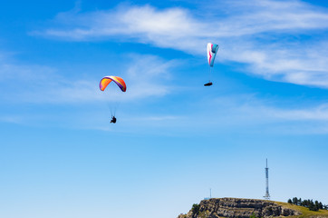 Paragliders soaring above the mountain top. Russia, Republic of Crimea. 06.13.2018. Flight of...