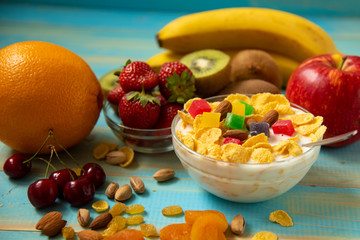 Tasty cornflakes with milk and fruits  in glass bowl 