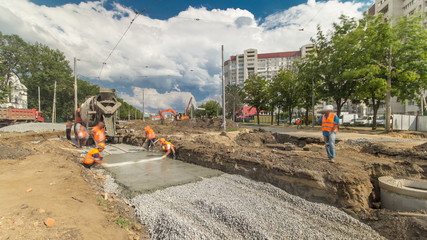 Concrete works for road maintenance construction with many workers and mixer timelapse