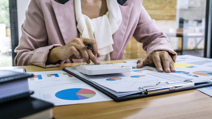 Business woman accountant working and calculating financial data on graph documents, doing finance...
