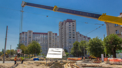Orange construction telescopic mobile crane moving tram rails timelapse.