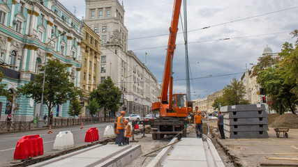Naklejka premium Installing concrete plates by crane at road construction site timelapse.