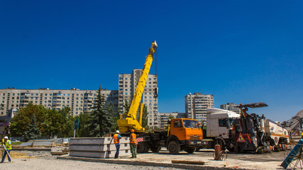 Fototapeta na wymiar Installing concrete plates by crane at road construction site timelapse.