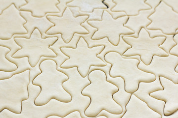 rolled dough with cut out figures for baking cookies