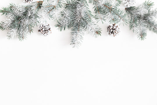 Christmas composition. Border made of fir tree branches, pine cones on white background. Christmas, winter, new year concept. Flat lay, top view, copy space