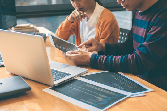 Professional Development programmer cooperating meeting and brainstorming and programming website working in a software and coding technology, writing codes and data code
