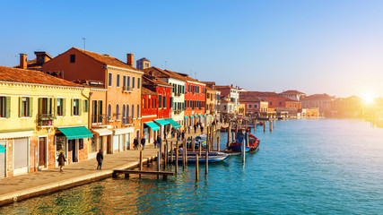 Street canal in Murano island, Venice. Narrow canal among old colorful brick houses in Murano, Venice. Murano postcard, Venice, Italy.