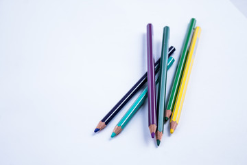 Fototapeta premium School equipment: colored pensils on white background.
