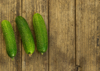 Fresh cucumbers on old wooden table