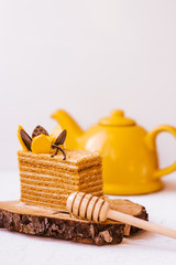Honey cake with teapot. Spring mood. Coffee break. Dessert on white background.Sweet dish on cut of...