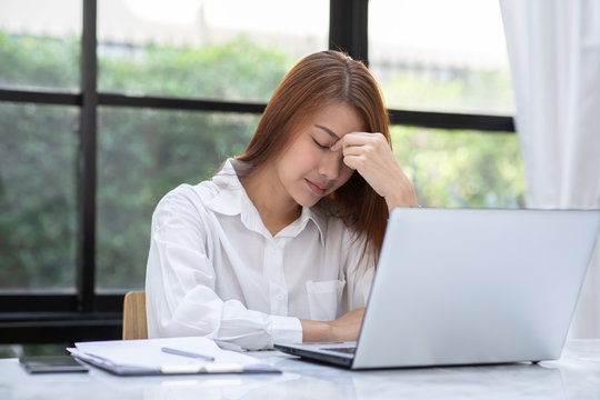 Business Asian woman have a Migraine so headache and stresses of her work