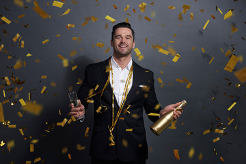Portrait of smiling man drinking alcohol at studio shot
