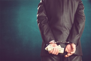 Cropped image of male hands in handcuffs behind his back