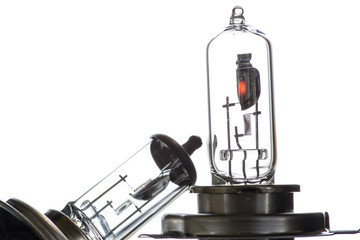 Incandescent lamp for dipped and main beam headlights with burning spiral on a white background