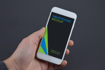 Smartphone Device Mockup held in Hand on anthracite gray Background