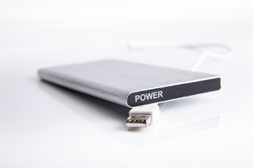 Powerbank. Ładowarka przenośna power bank. Nowoczesny, srebrny power bank na białym  tle.