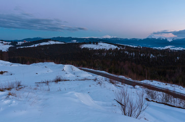 Fototapeta na wymiar Evening twilight winter mountain ridge panorama