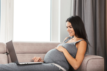 Beautiful young pregnant woman at home